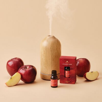Thymes Simmered Cider Diffuser Oil Beside Electric Diffuser and Apples